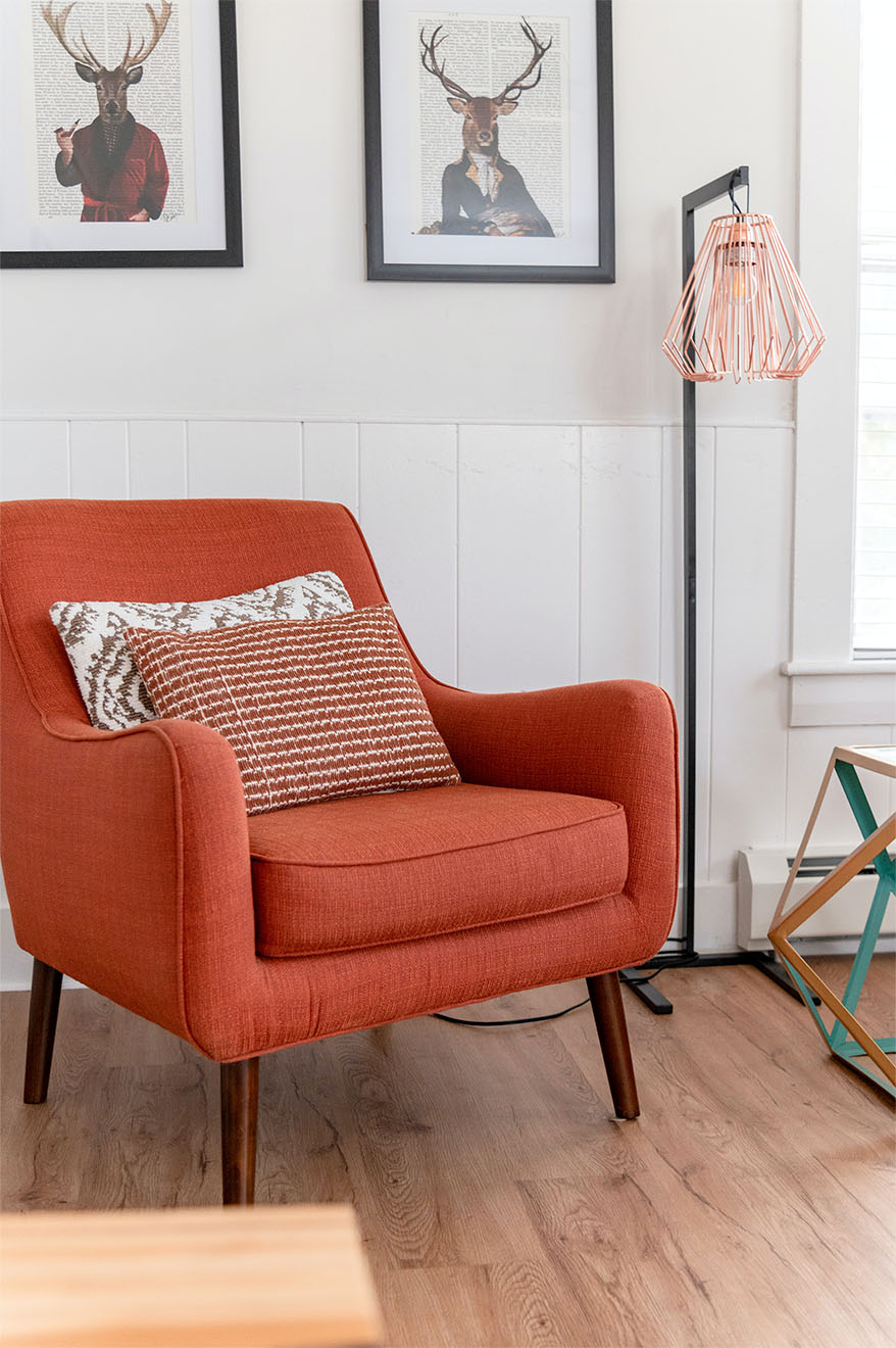 a red chair with cushions on in a lounge