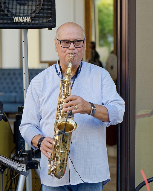 man in blue shirt playing saxophone